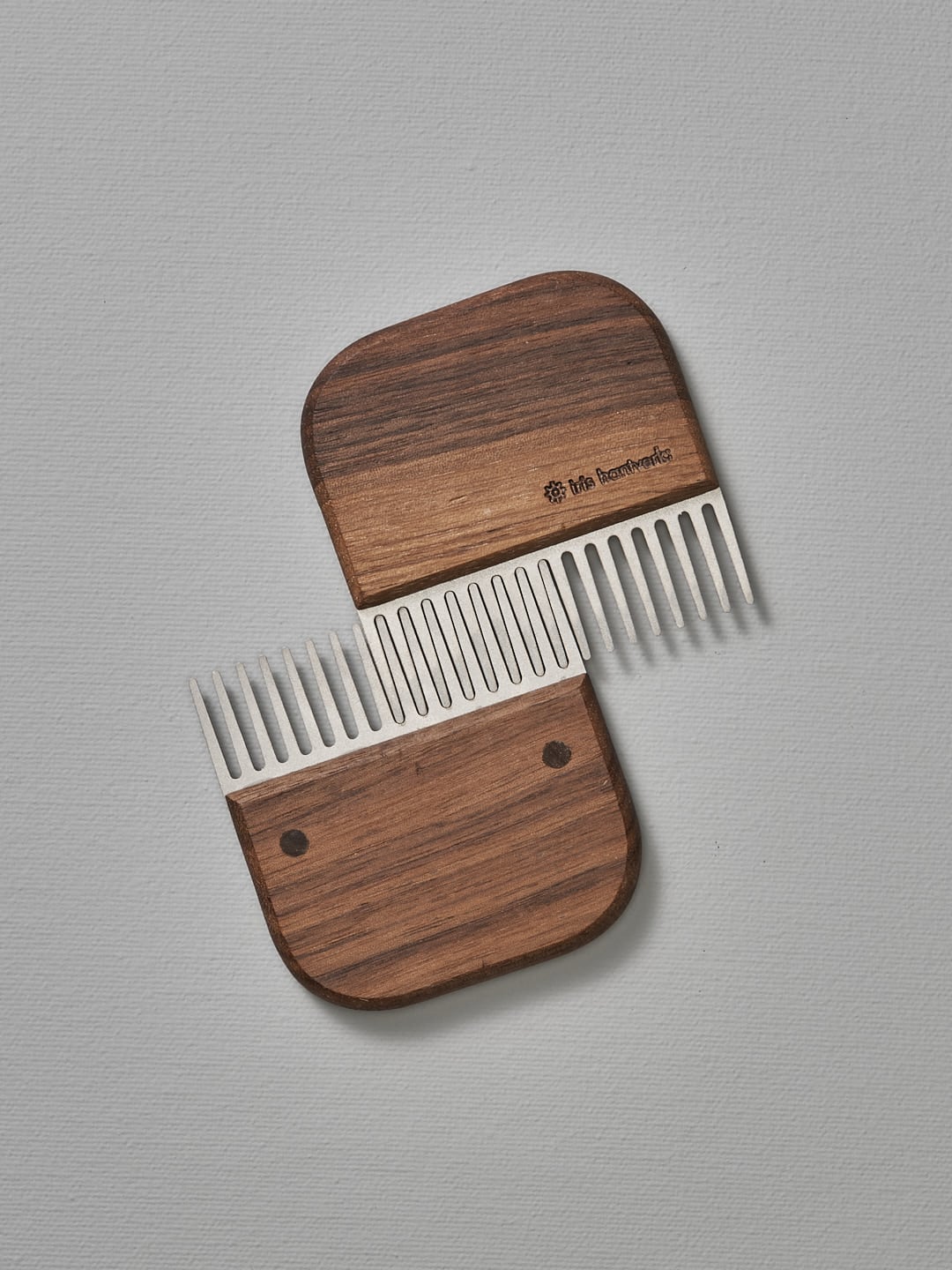 A Beard Comb – Walnut by Iris Hantverk on top of a white surface.