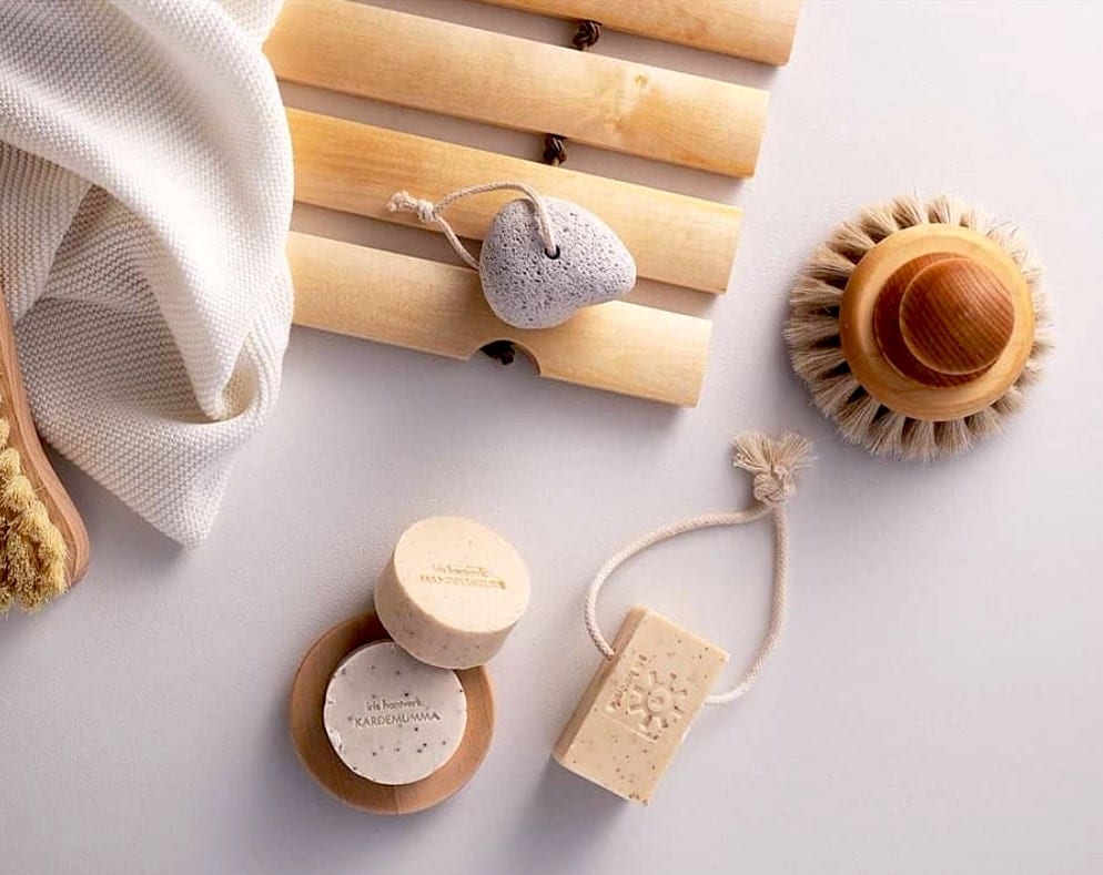 A set of Iris Hantverk wooden soaps and brushes on a white surface.