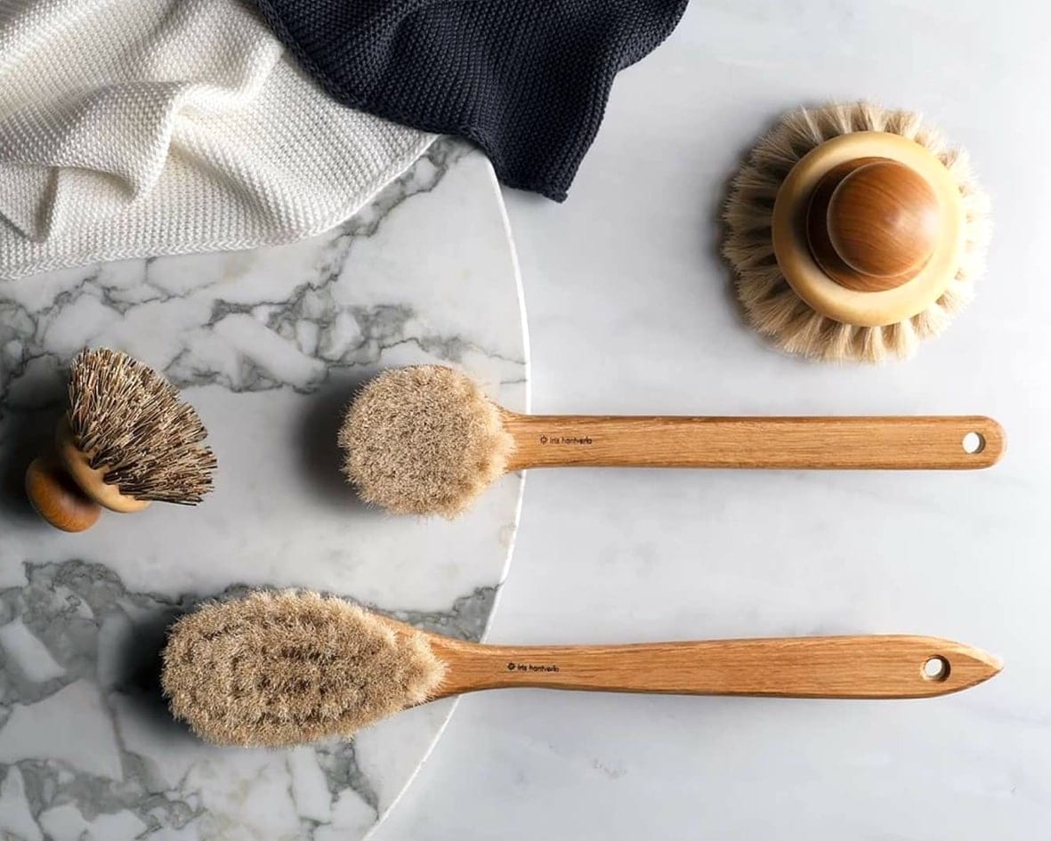 A set of Iris Hantverk Body Brushes – Round Head on a marble table.