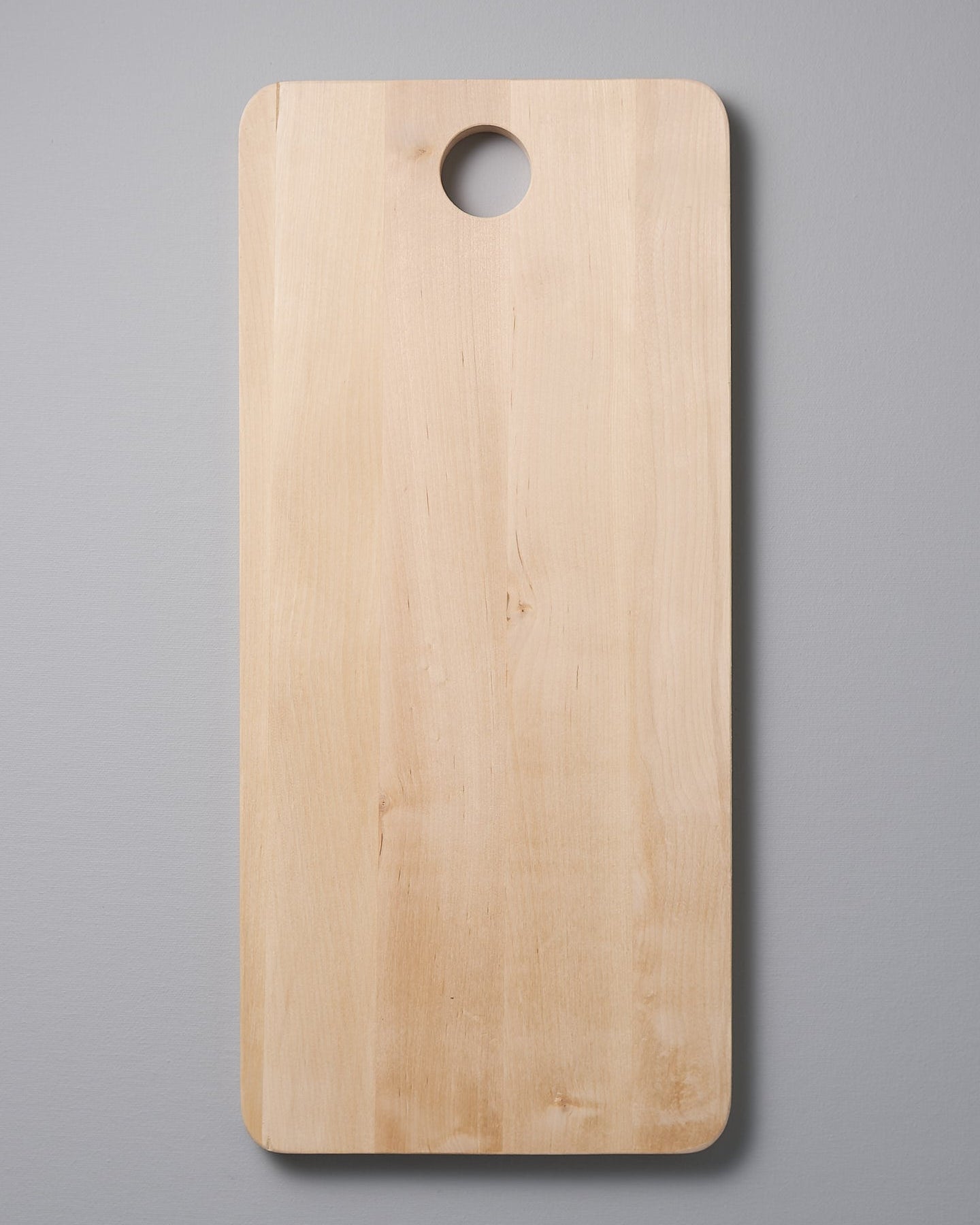 An Iris Hantverk Birch Chopping Board – Large on a gray background.