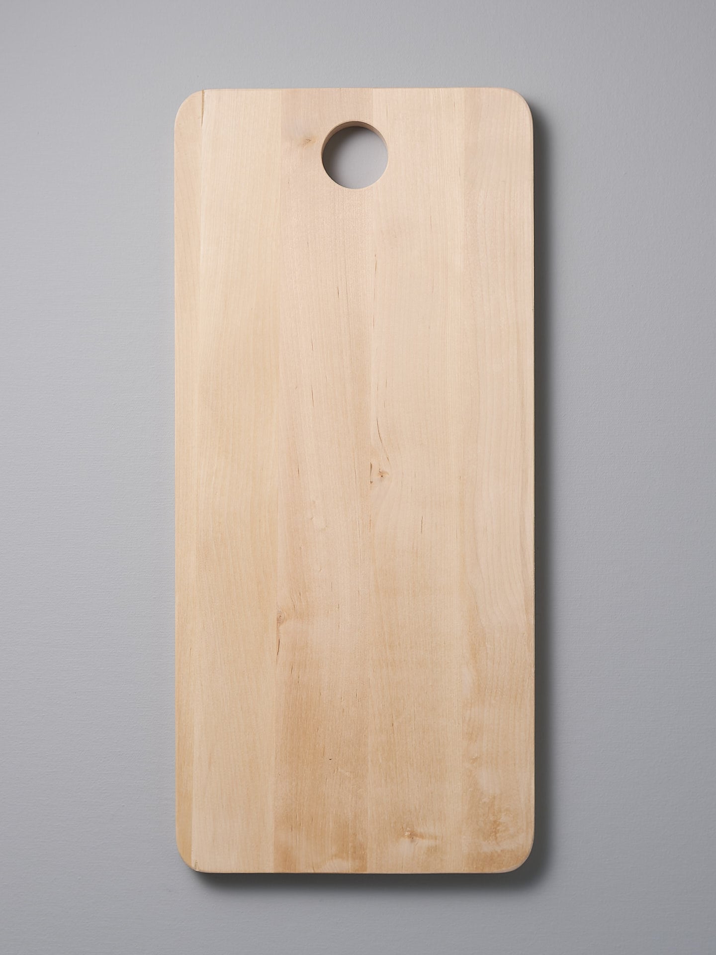 An Iris Hantverk Birch Chopping Board – Large on a gray background.