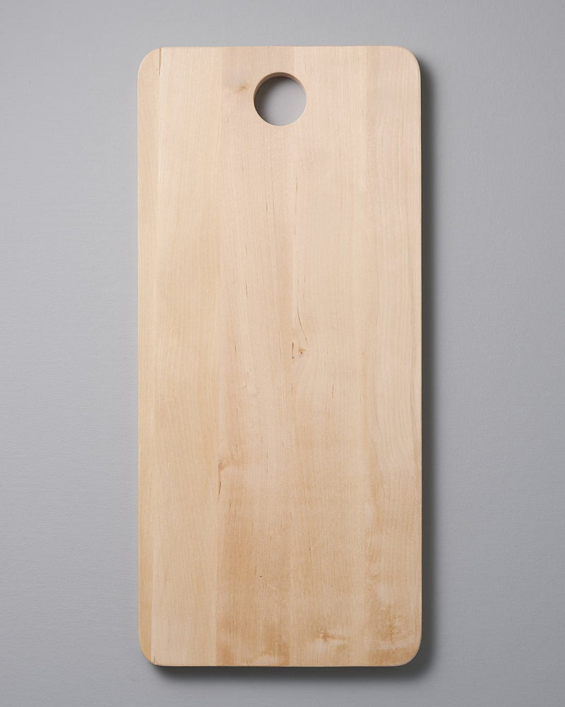 An Iris Hantverk Birch Chopping Board – Large on a gray background.
