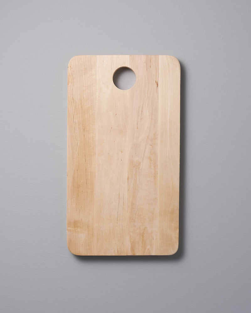 An Iris Hantverk Birch Chopping Board – Medium on a gray background.