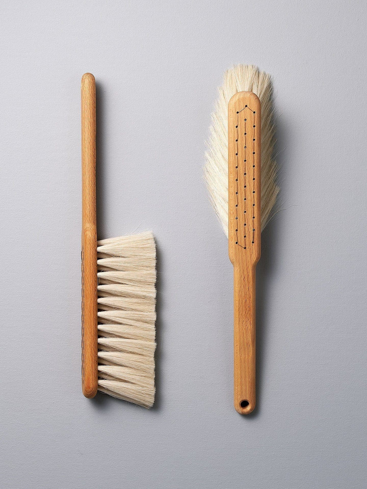 Two Dust Brushes - Beechwood &amp; Goat Hair by Iris Hantverk on a grey surface.