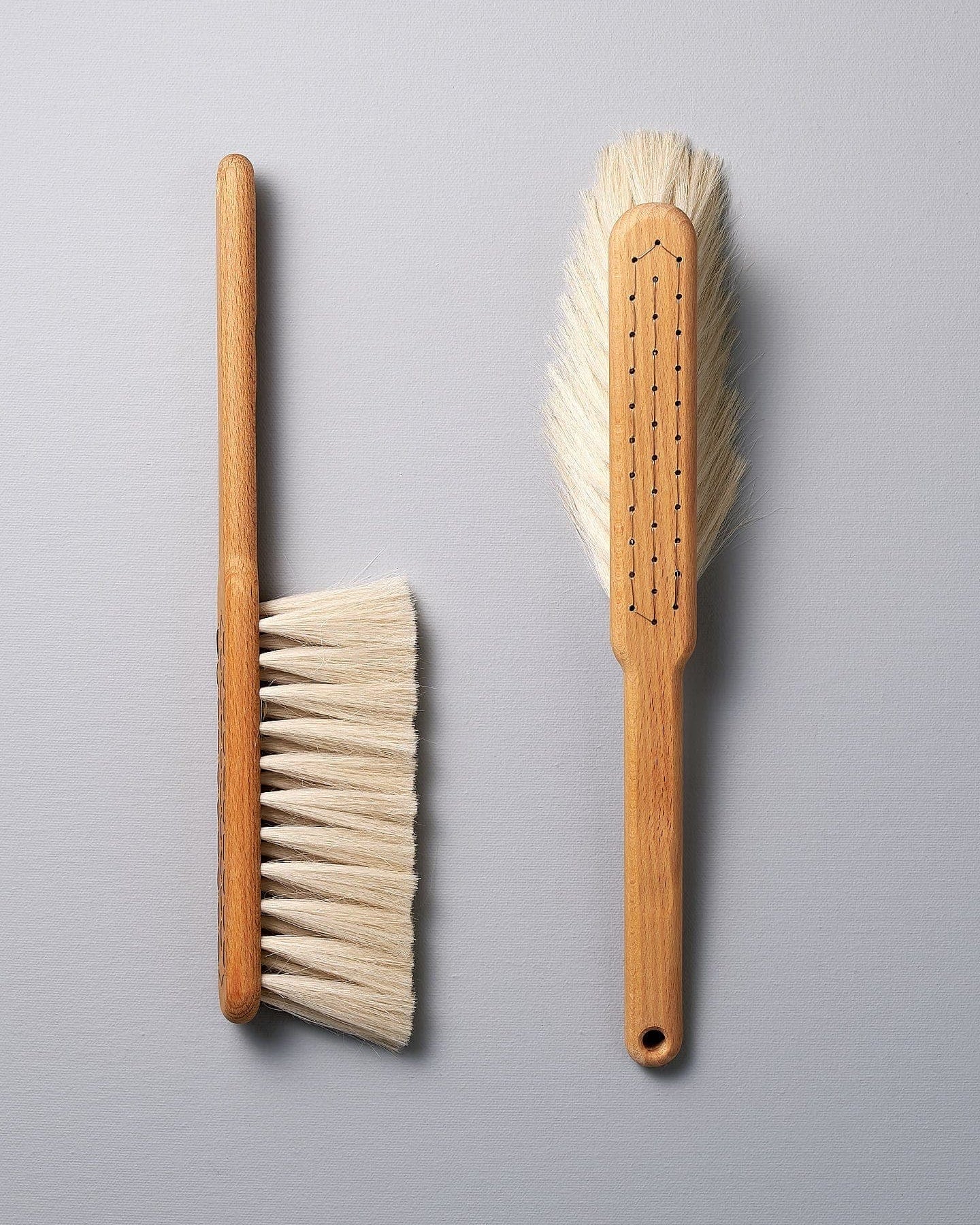 Two Dust Brushes - Beechwood & Goat Hair by Iris Hantverk on a grey surface.
