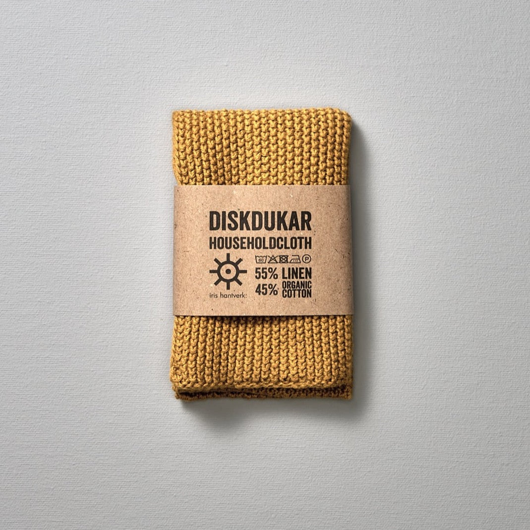 A yellow Linen Household Cloth - Four Colours from Iris Hantverk, a linen/cotton blend knitted dishcloth with a label on it that is absorbent, making it an ideal household cloth.
