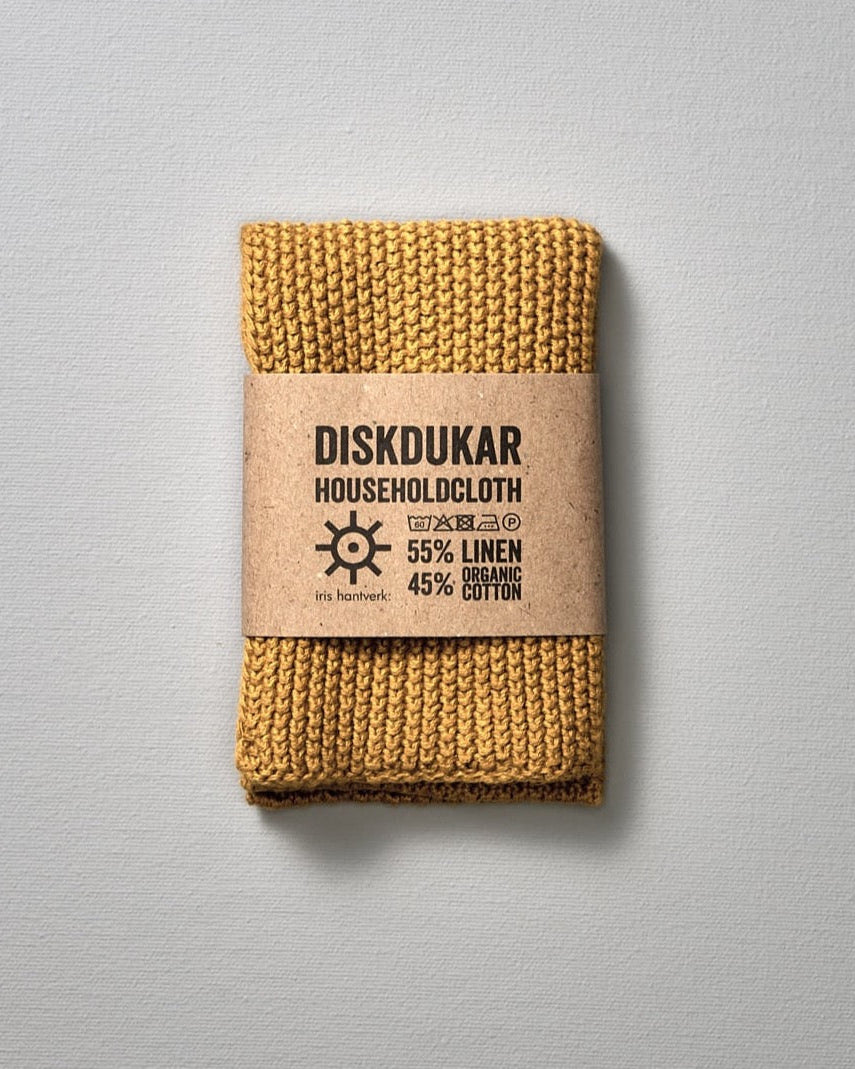 A yellow Linen Household Cloth - Four Colours from Iris Hantverk, a linen/cotton blend knitted dishcloth with a label on it that is absorbent, making it an ideal household cloth.
