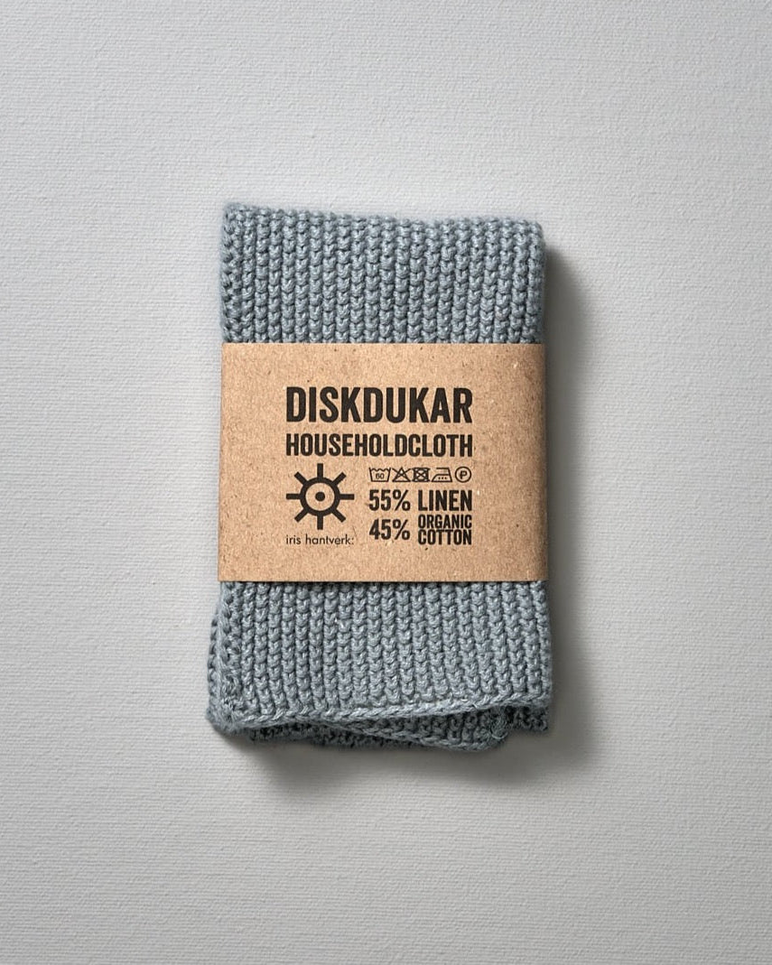 A blue Linen Household Cloth – Four Colours with the word disikurr on it, made from a linen/cotton blend for a household cloth that is absorbent, by Iris Hantverk.