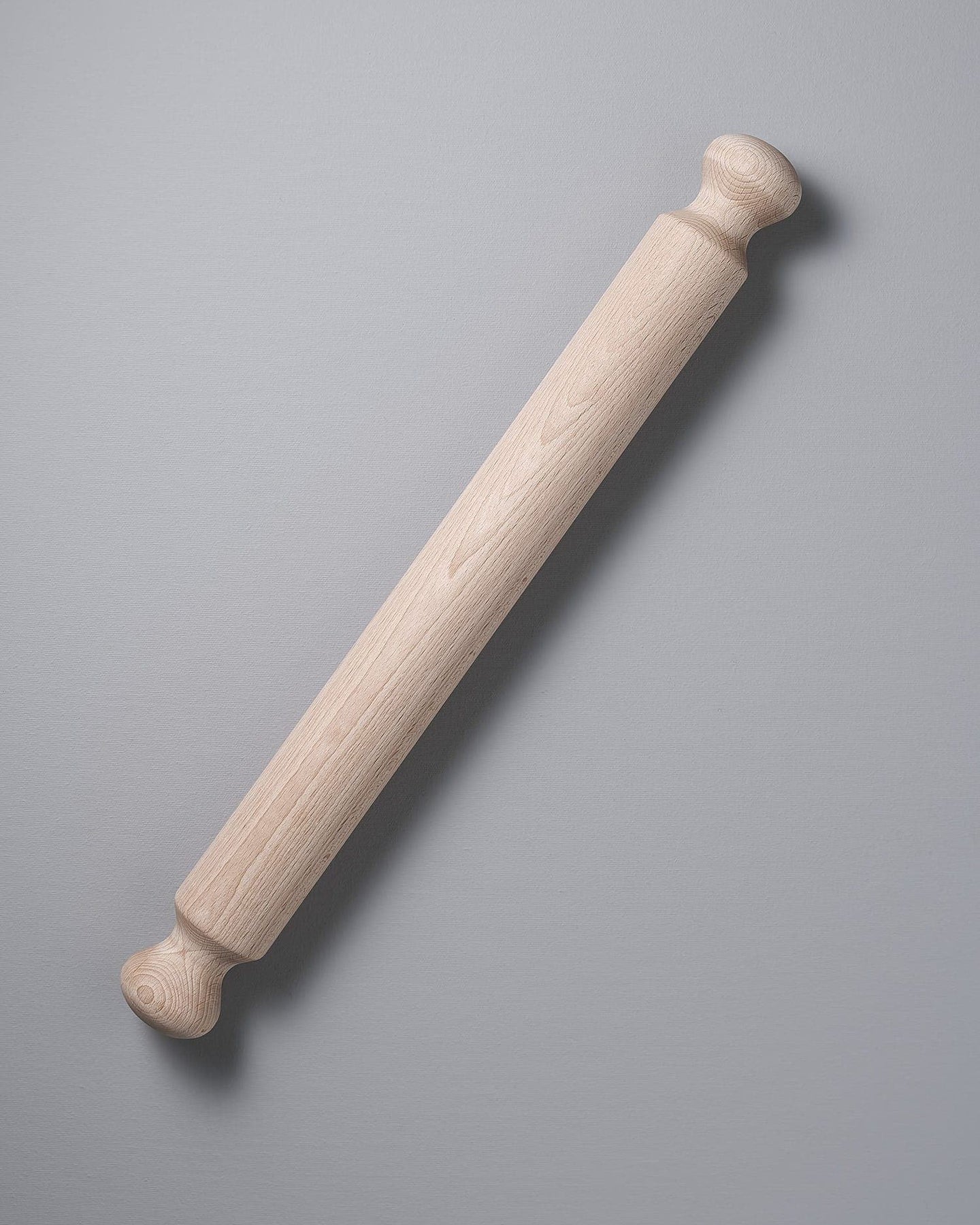 An Iris Hantverk Beechwood Rolling Pin on a grey background.