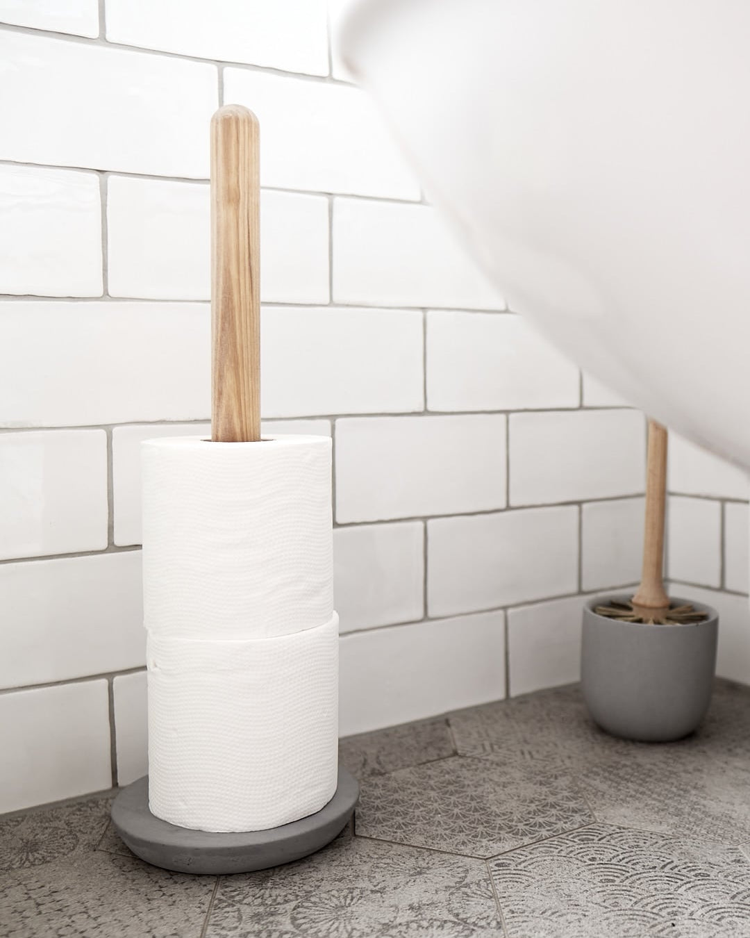 An Iris Hantverk toilet roll holder in a bathroom with a wooden handle.