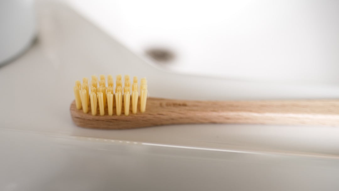 An Iris Hantverk wooden toothbrush – Biobased Bristles sits on top of a sink.