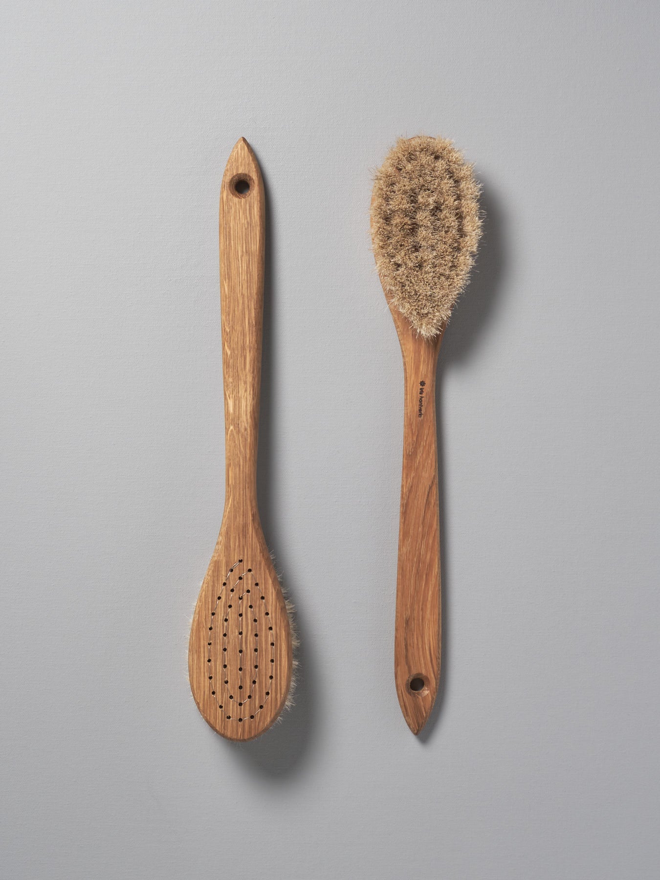 Two Iris Hantverk Body Brushes – Oval Head next to each other on a grey background.