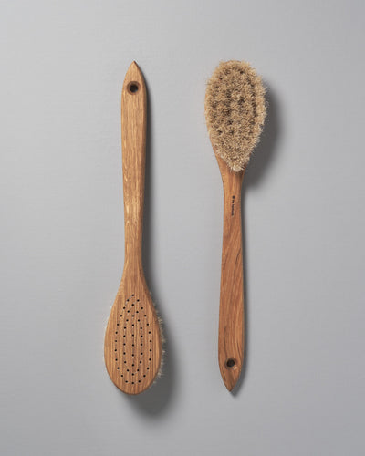 Two Iris Hantverk Body Brushes – Oval Head next to each other on a grey background.