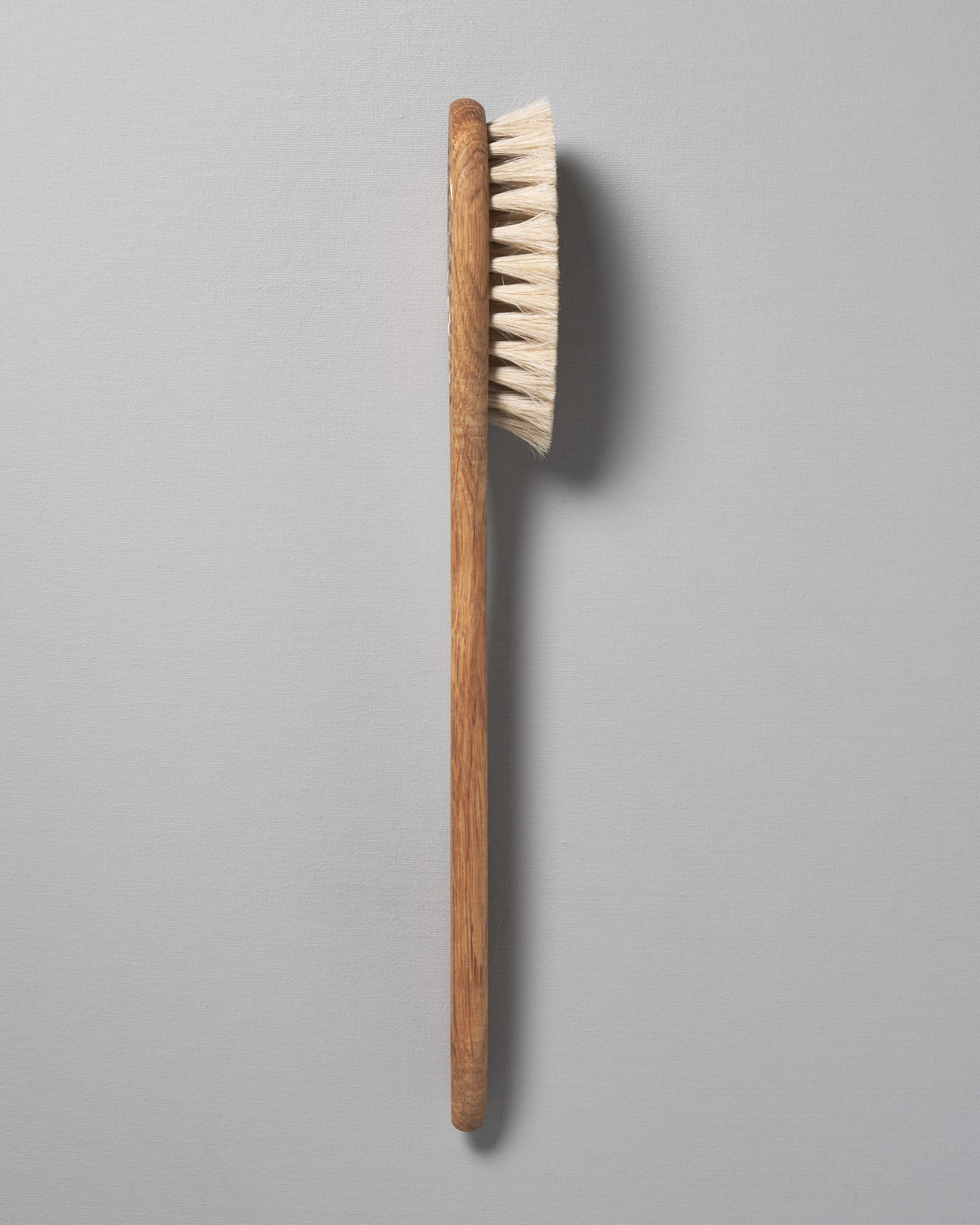 Two Iris Hantverk Body Brushes – Oval Head next to each other on a grey background.