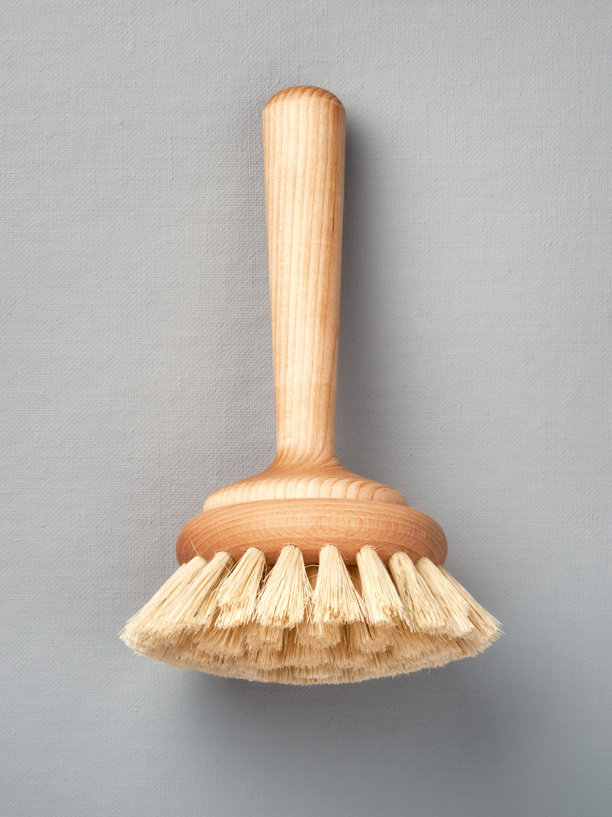 An Iris Hantverk Bathroom Cleaning Brush on a gray background.