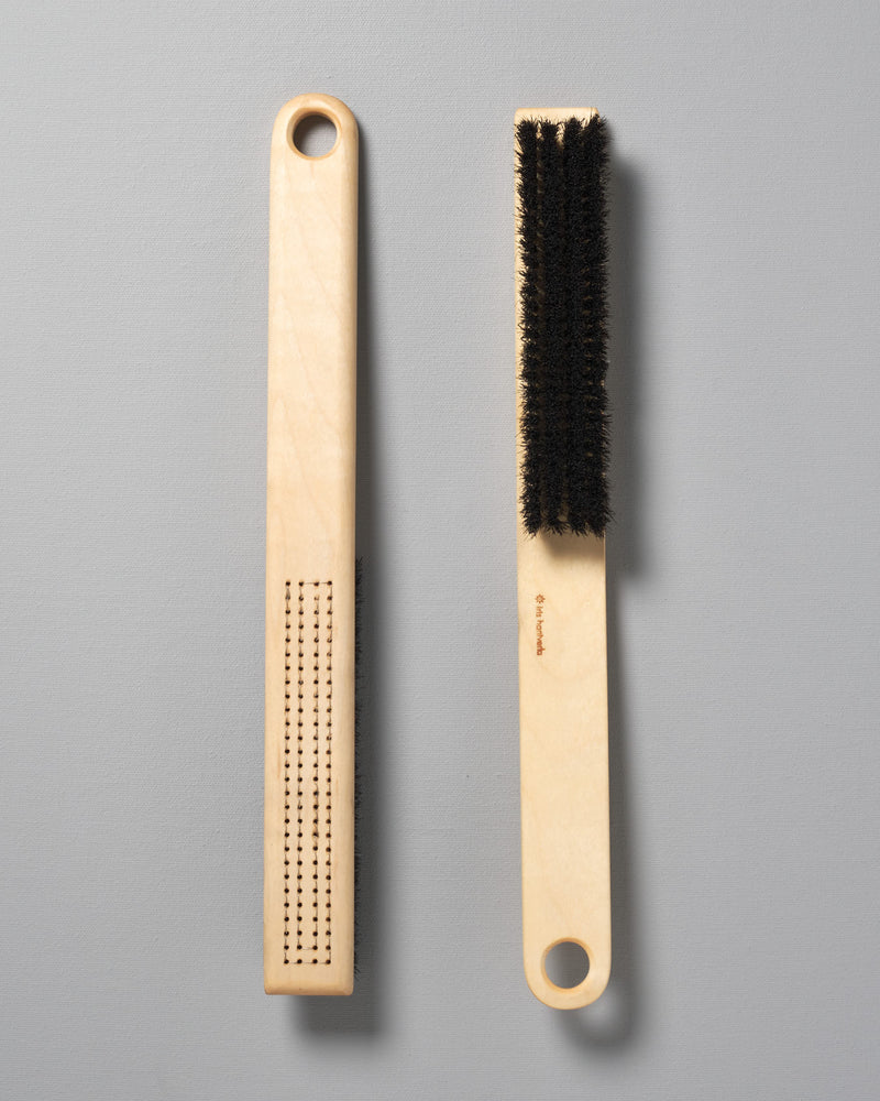 Two Iris Hantverk clothes brushes next to each other on a grey surface.