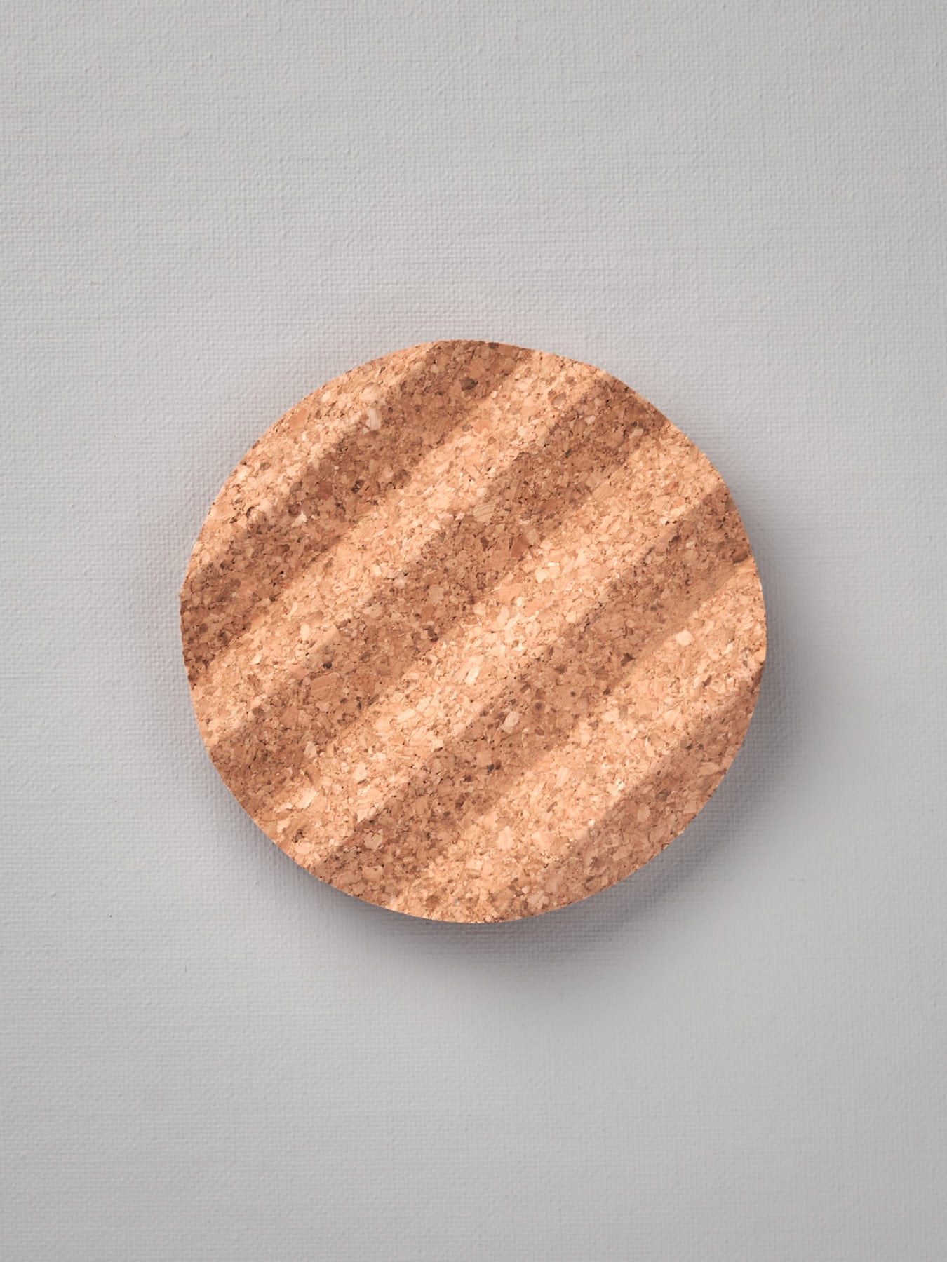 An Iris Hantverk Cork Soap Dish with a striped pattern on it.