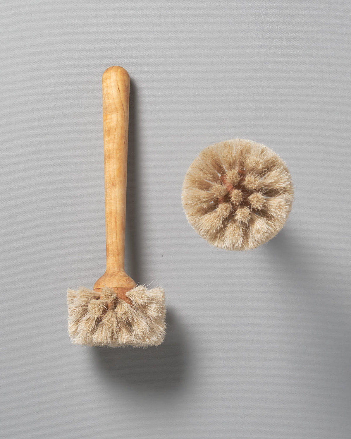 Two Iris Hantverk Glass Brushes on a grey background.