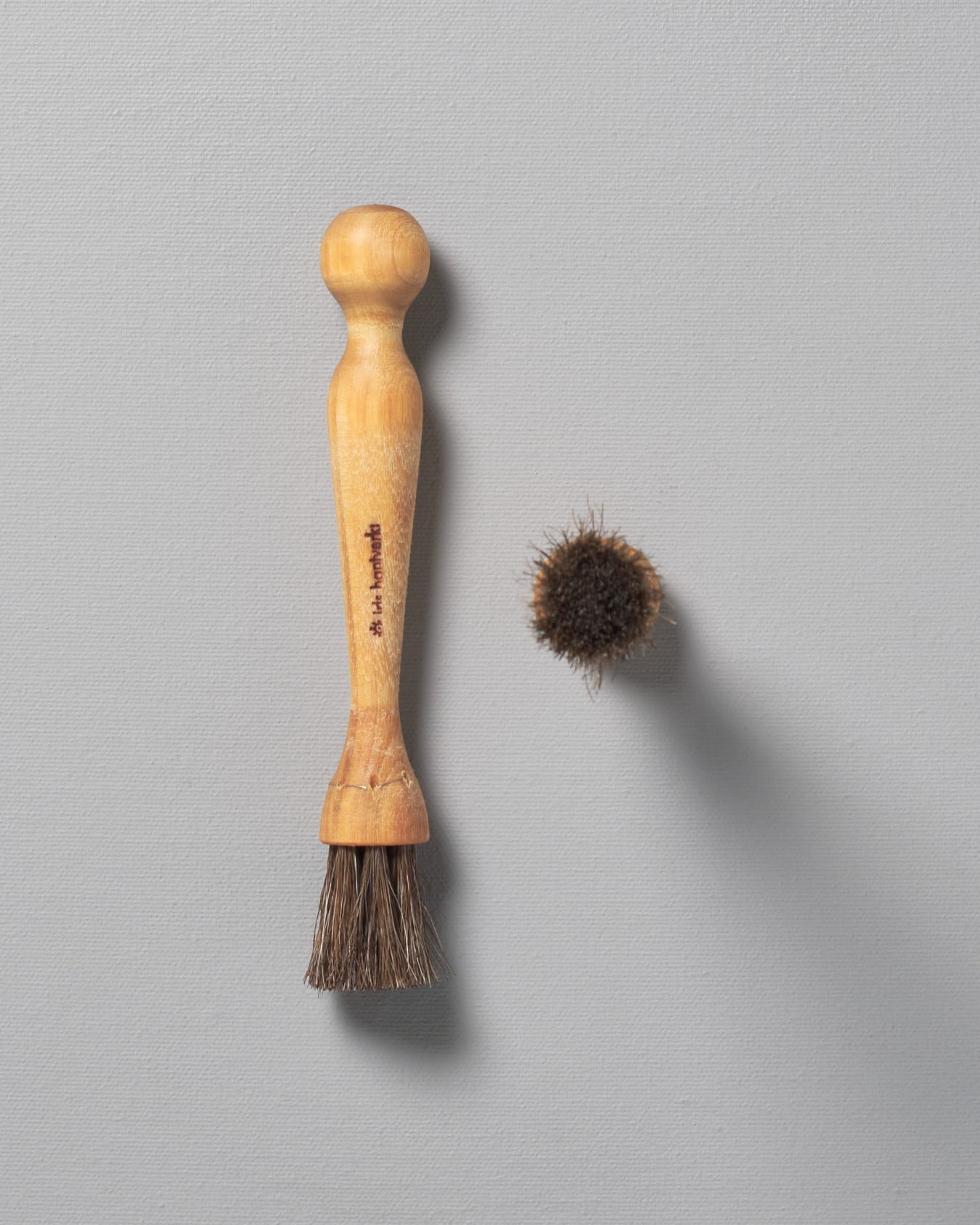 A Iris Hantverk Mushroom Brush next to a wooden comb.