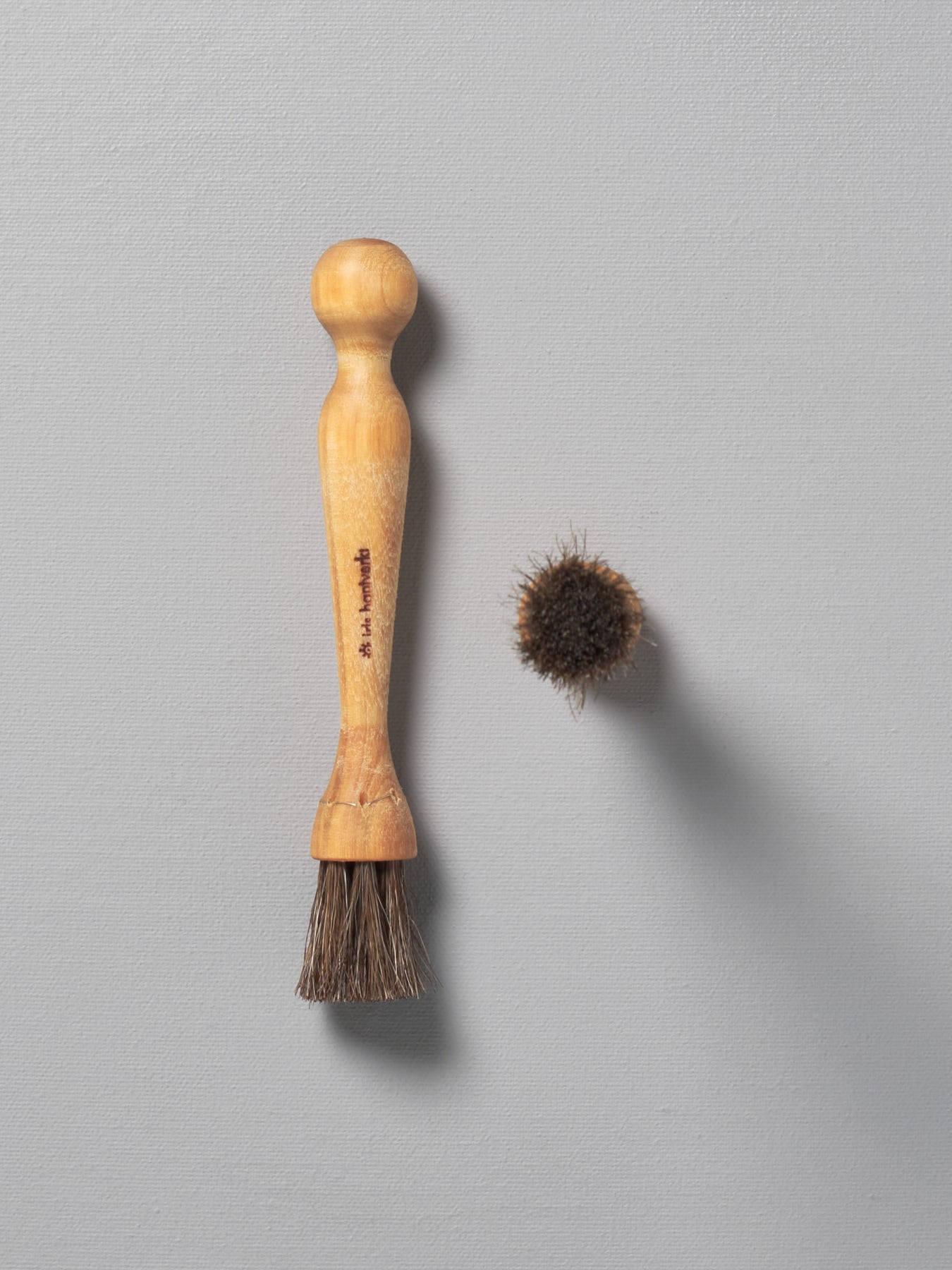 A Iris Hantverk Mushroom Brush next to a wooden comb.