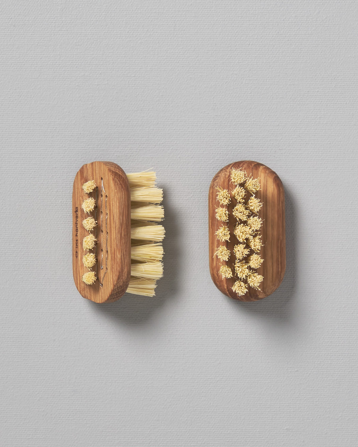 Two Iris Hantverk Nail Brush – Small on a grey surface.