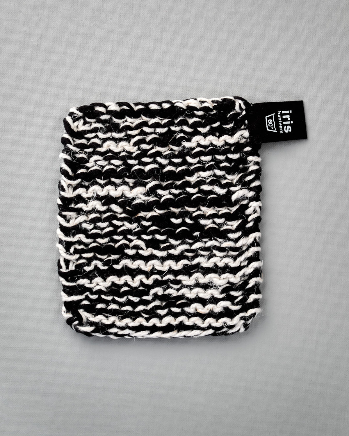 An Iris Hantverk black and white Pot & Oven-tray Holder with a tag on it.