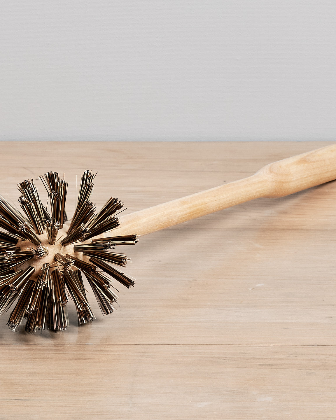 A Toilet Brush - Replacement by Iris Hantverk sitting on top of a wooden table.