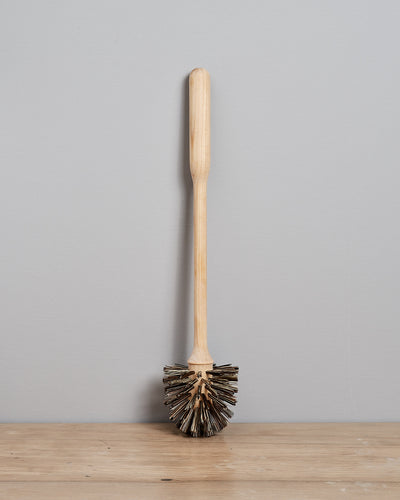 A Toilet Brush - Replacement by Iris Hantverk sitting on top of a wooden table.
