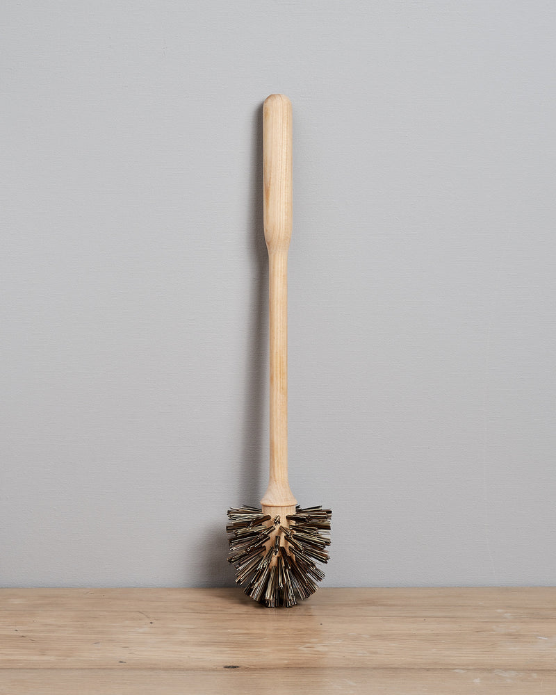 A Toilet Brush - Replacement by Iris Hantverk sitting on top of a wooden table.
