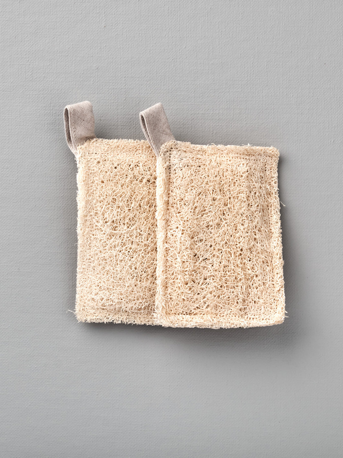 A pair of Loofah Scouring Pad – 2pk on a grey background from Iris Hantverk.