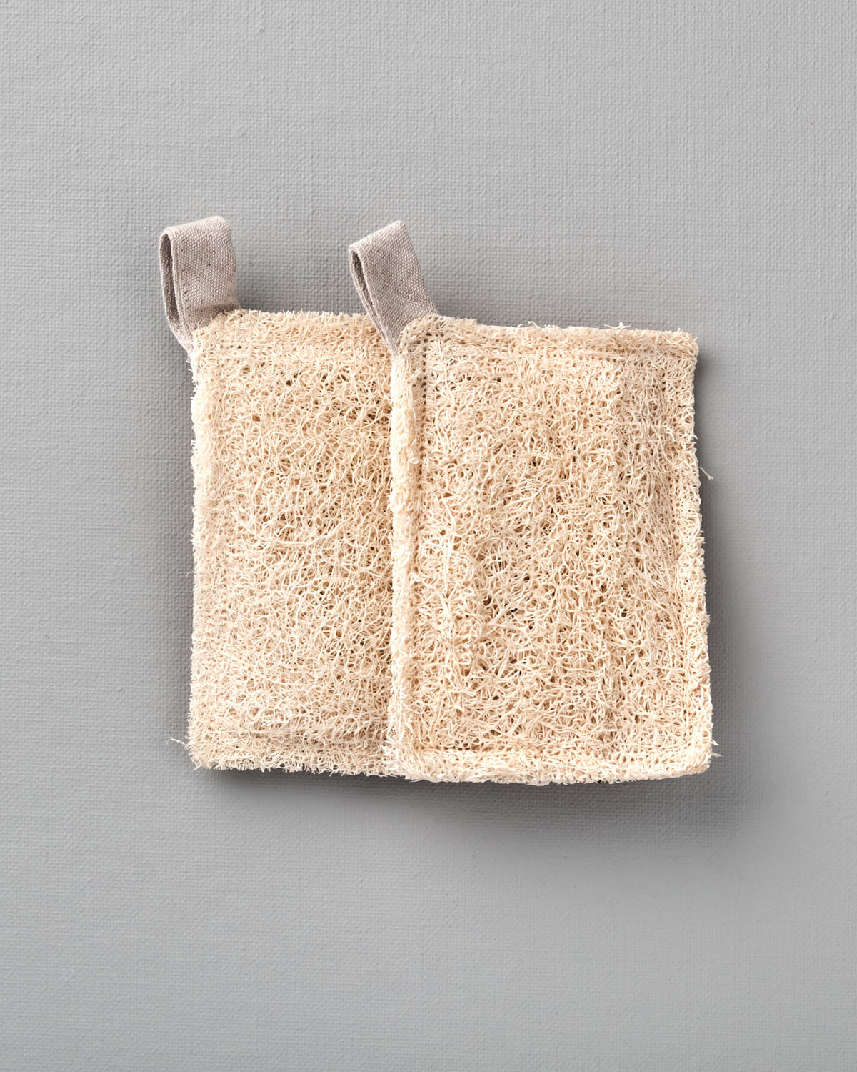 A pair of Loofah Scouring Pad – 2pk on a grey background from Iris Hantverk.