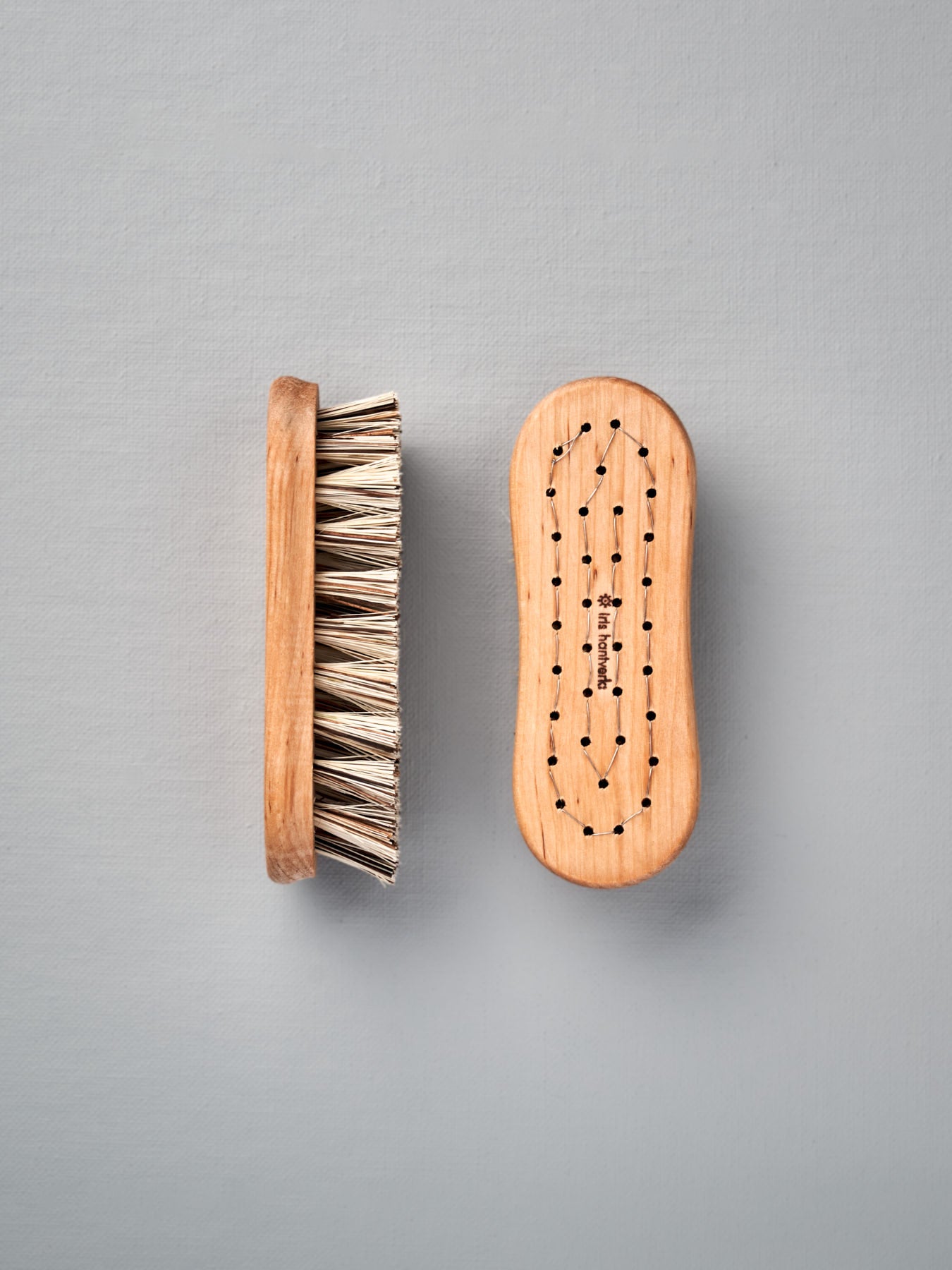 Two Iris Hantverk Vegetable Brushes on a grey background.