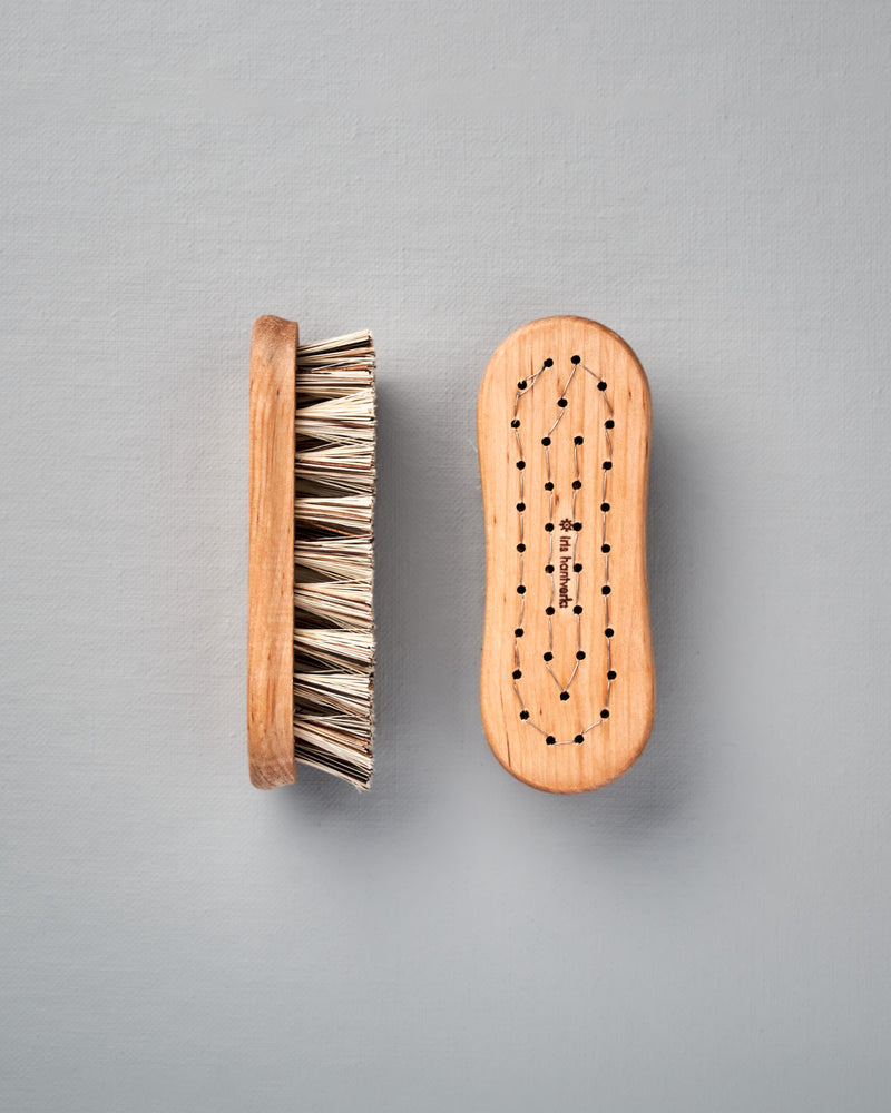 Two Iris Hantverk Vegetable Brushes on a grey background.