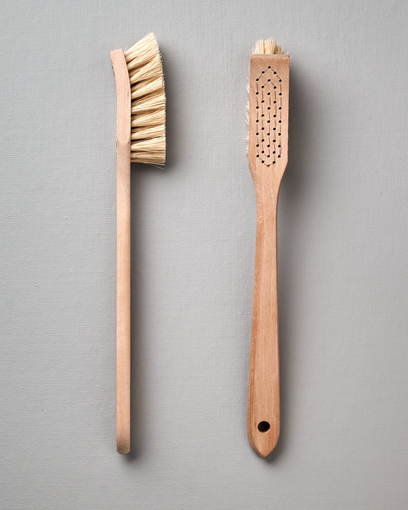 Two Iris Hantverk dish brushes on a grey background.