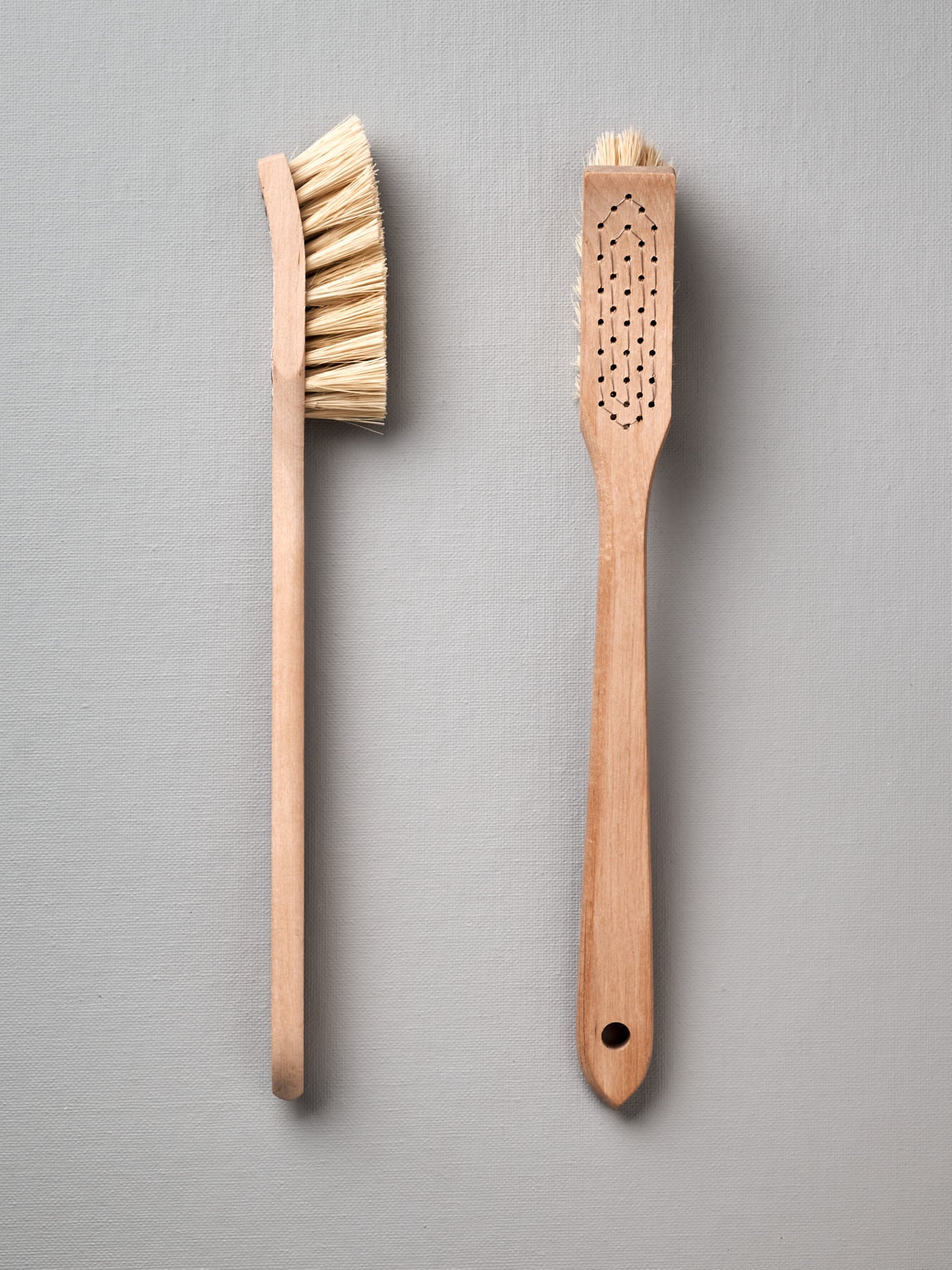 Two Iris Hantverk dish brushes on a grey background.