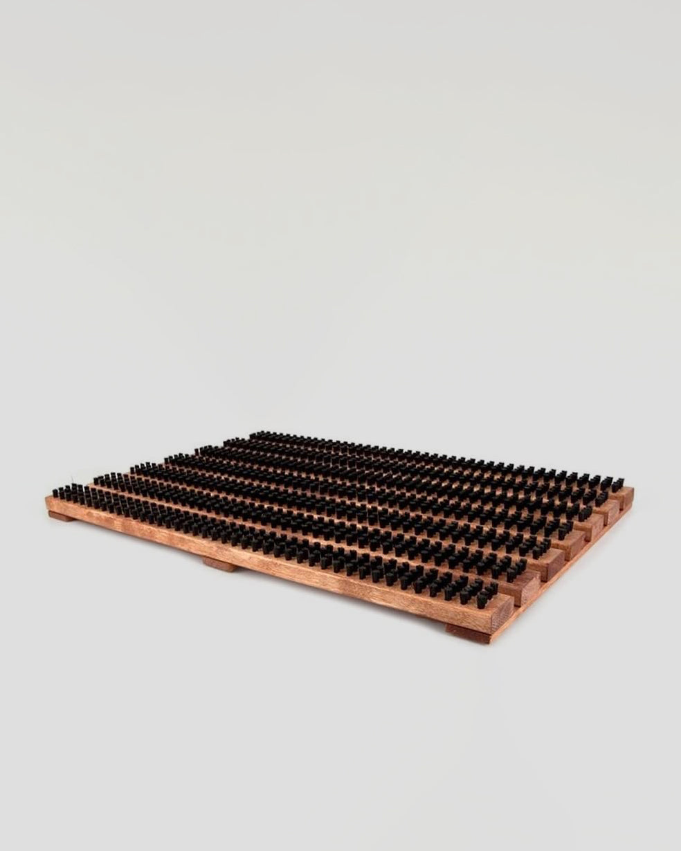 The Iris Hantverk Wooden Doormat with Bristles – Standard features multiple rows of small black cylindrical pegs, offering both style and functionality reminiscent of a Swedish entrance mat.