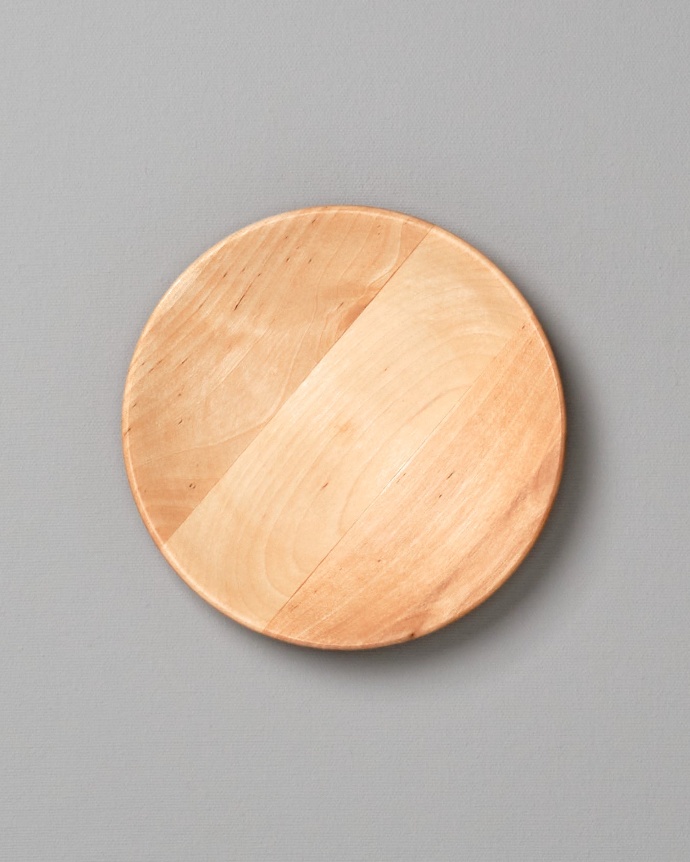 An Iris Hantverk wooden plate – large on a gray background.