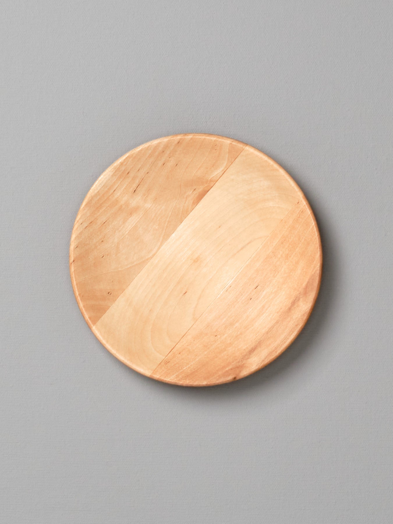 An Iris Hantverk wooden plate – large on a gray background.