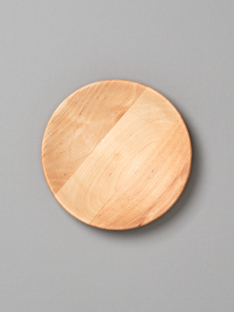An Iris Hantverk wooden plate – large on a gray background.