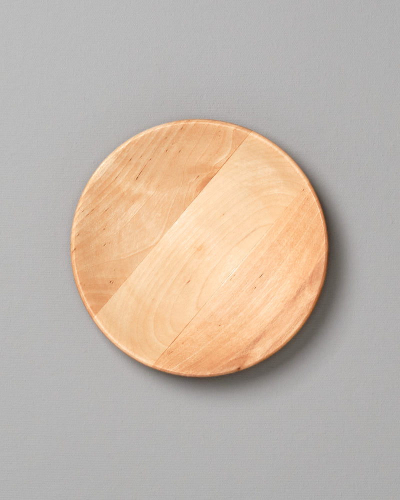 An Iris Hantverk wooden plate – large on a gray background.
