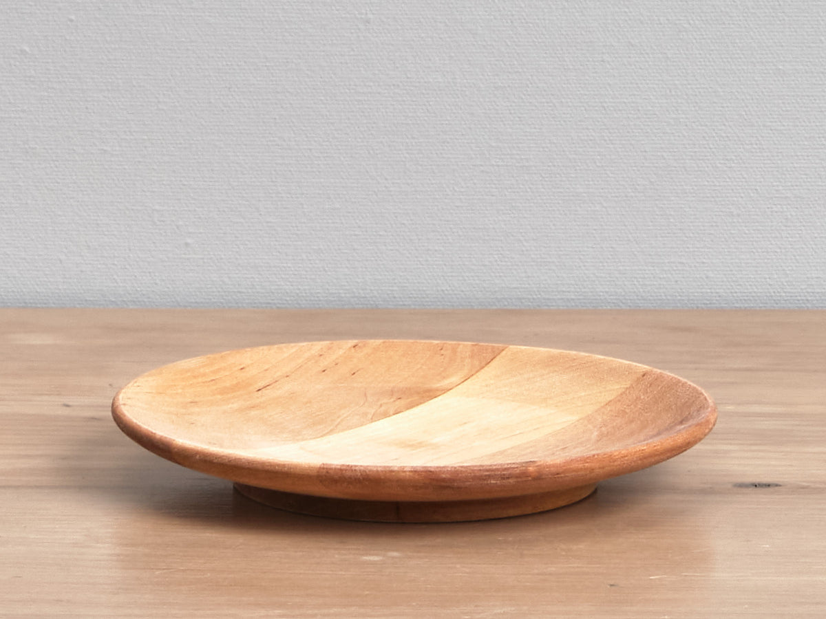 An Iris Hantverk wooden plate on a table.