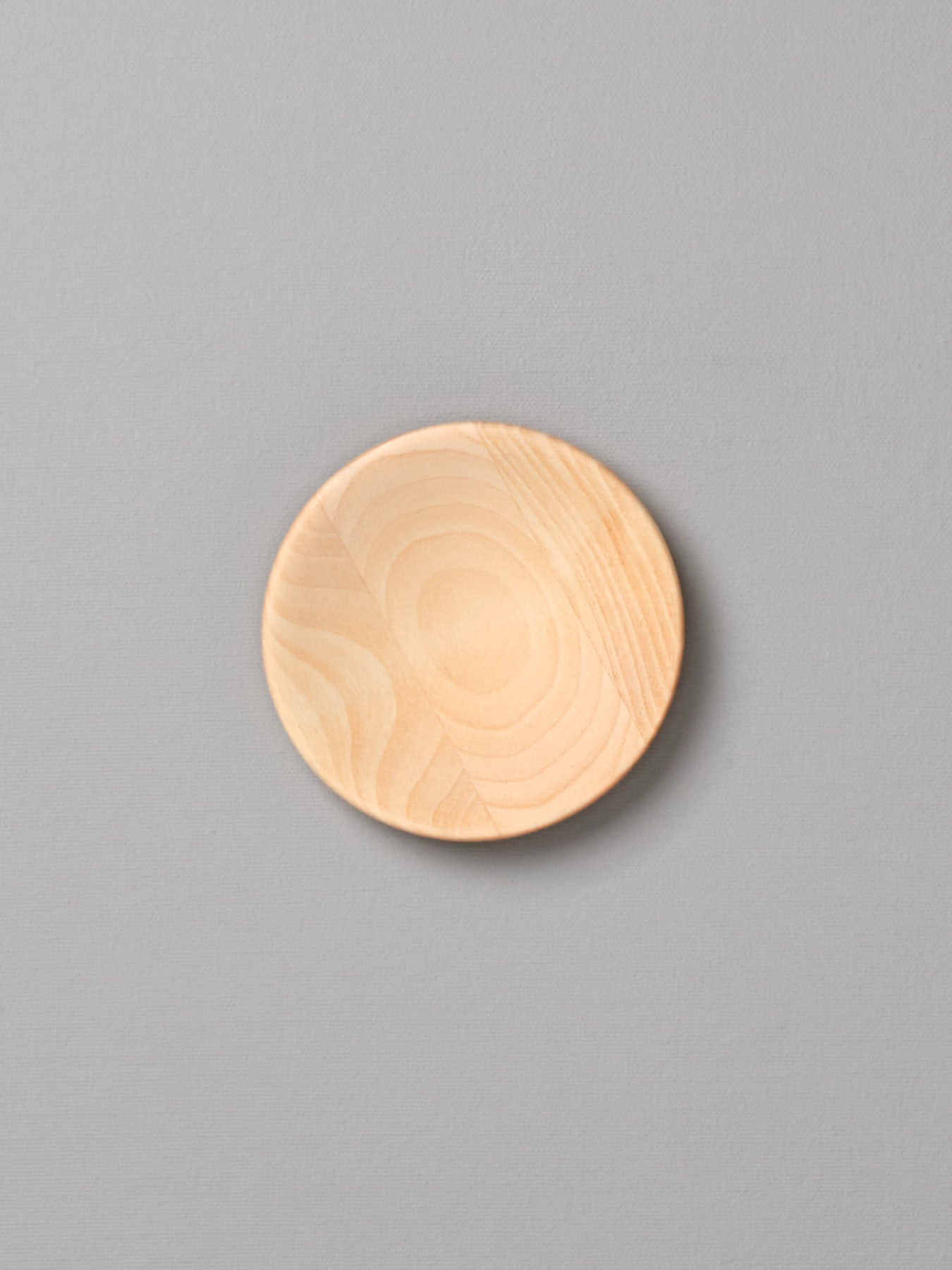 An Iris Hantverk small wooden plate on a gray background.