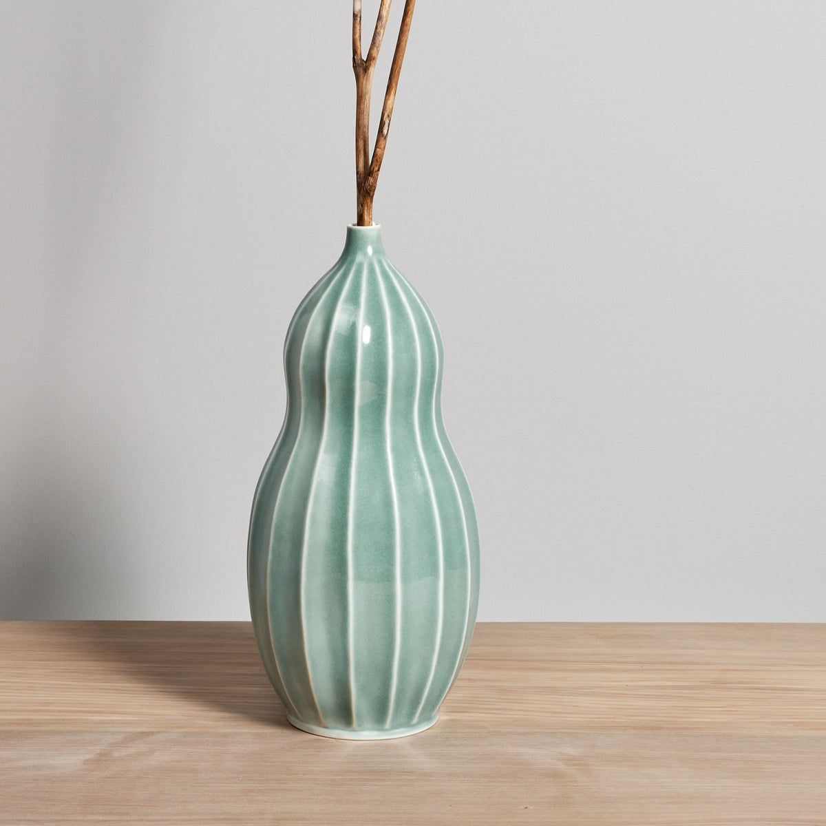 A Gourd Vase - Celadon with sticks in it, made by Jino Ceramic Studio.