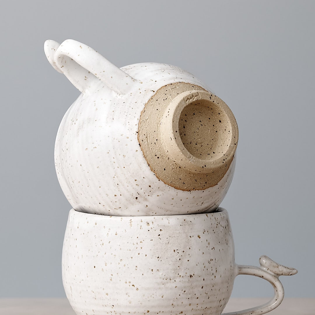 A Bird Handle Cup – White by Jino Ceramic Studio sitting on top of each other.