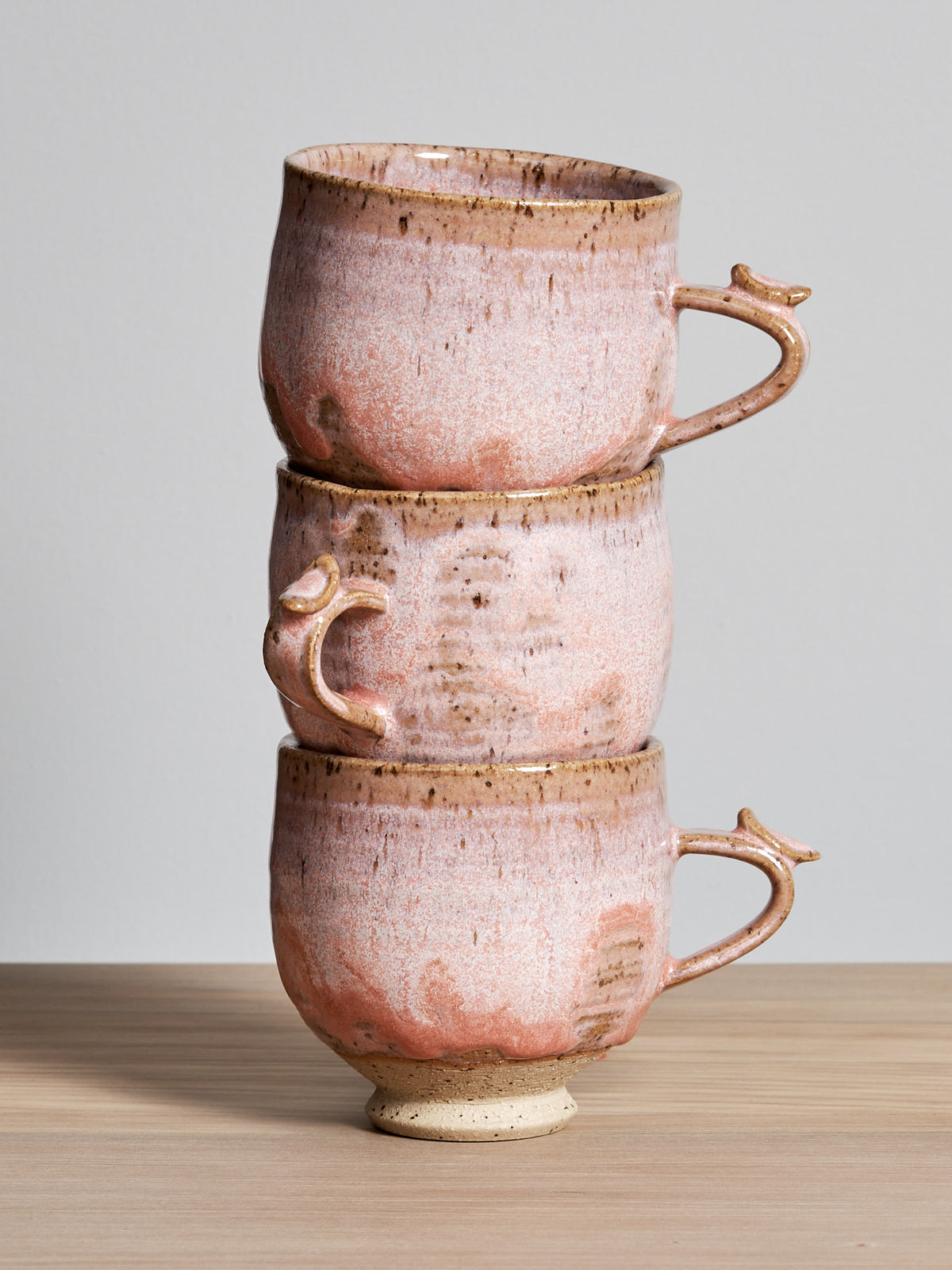Three Bird Handle Cups - Rhubarb by Jino Ceramic Studio stacked on top of each other.