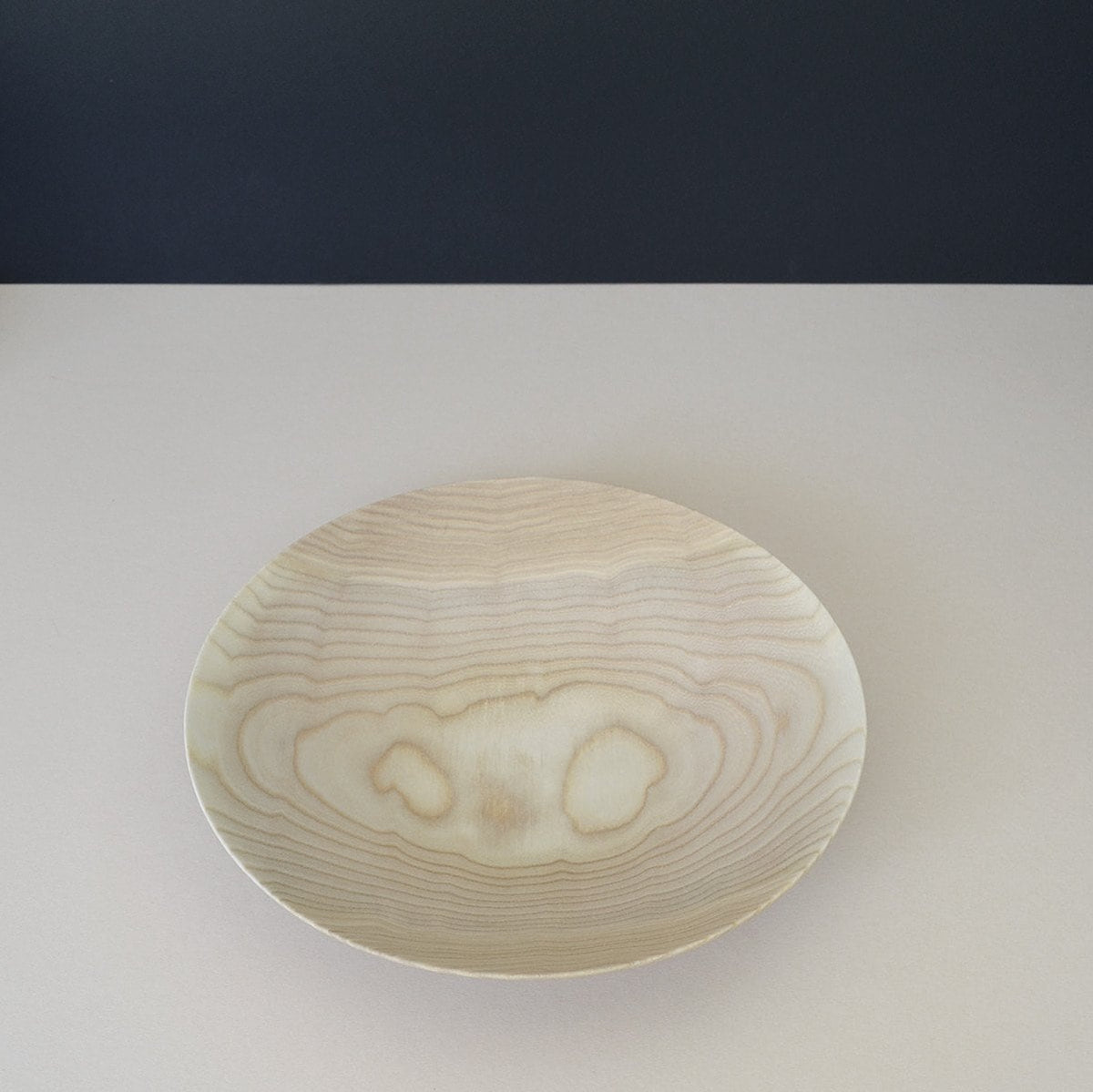 A white plate with a wood grain on it would be the Wooden Plate - Medium made by Kihachi.