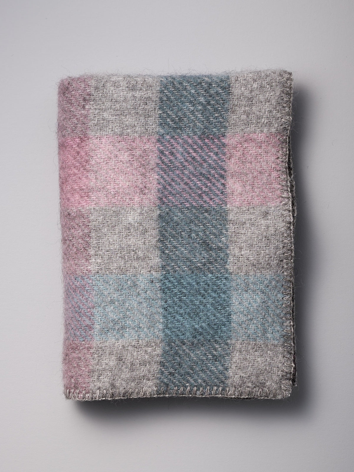 A Klippan Gotland Wool Baby Throw – Multi Pastel blanket on a white surface.