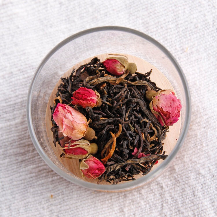 A cup of Yunnan Rose black tea with roses in it by Kaputi Studio.