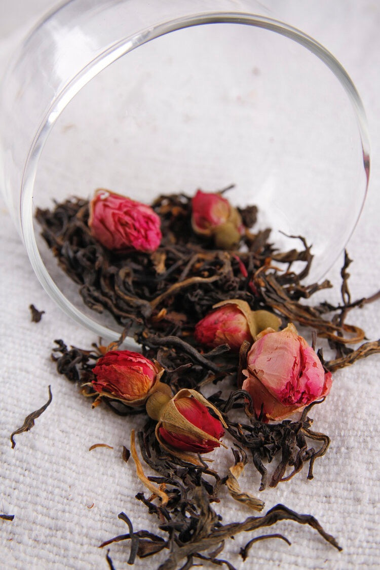 A cup of Yunnan Rose tea from Kaputi Studio with rose petals in it.