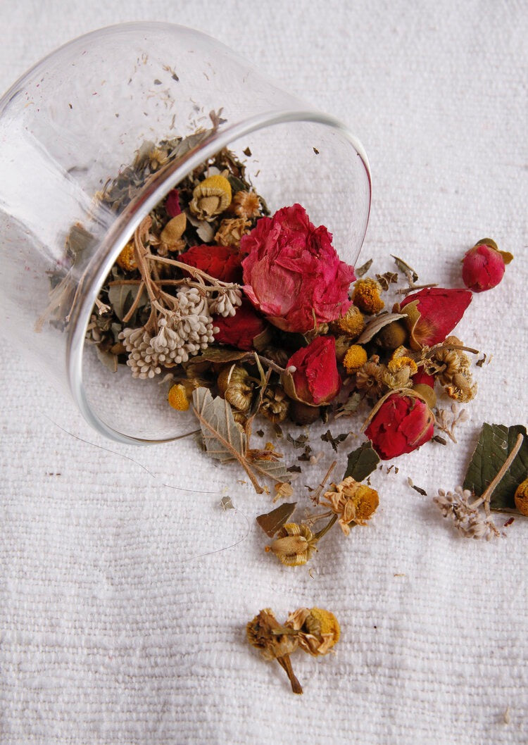 A glass of Kūmarahou Calm tea with dried flowers in it from Kaputi Studio.